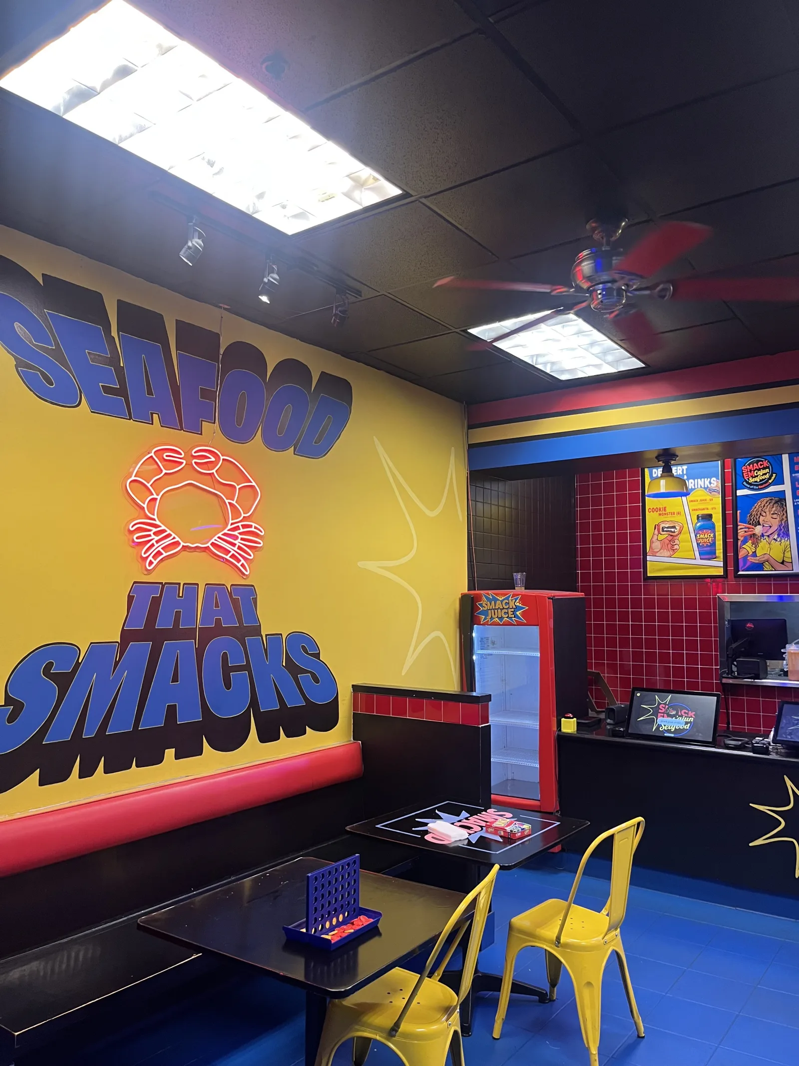 Interior of the Downtown Los Angeles SmackEm Seafood location with navy, red, yellow, and blue decor